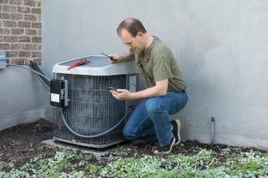 Man repairing AC unit.