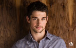 Man standing in front of wood paneling at a rental home.
