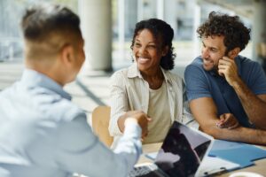 A happy couple shakes hands with their new property manager.