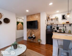 Small apartment with a neat kitchen and living room, including a TV, designed for efficient and cozy living.