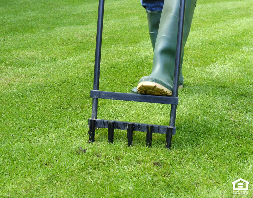 Manually Aerating the Lawn at a Rental Home in Bluff Springs