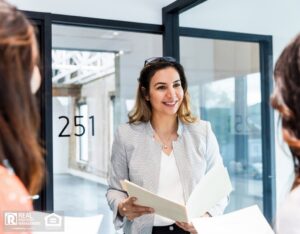 A smiling property manager reviews move in documents with the new tenants.