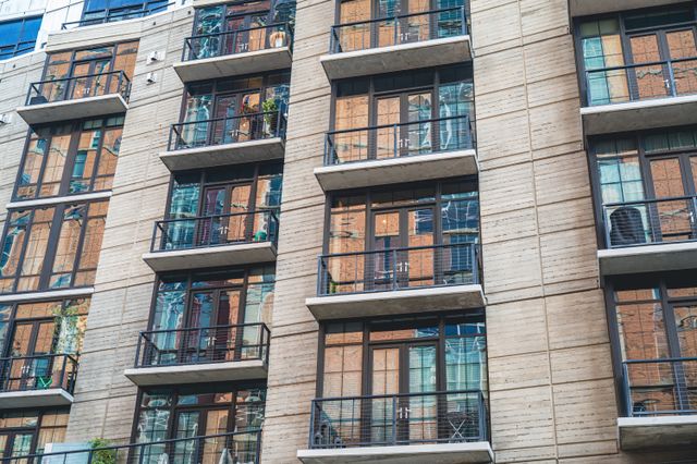 the exterior of an apartment with glass windows