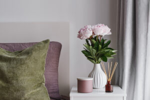 Fresh flowers and incense on a table near the window
