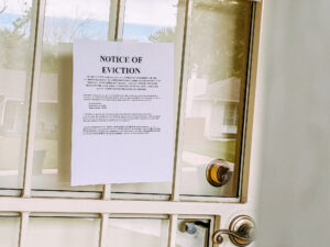Paper Eviction Notice Taped to the Front Door of a Home in a Residential Suburban Neighborhood