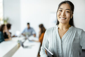 business woman smiling confidently with a group in the background