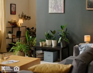 A cozy living room featuring a couch, a table, and vibrant green plants.