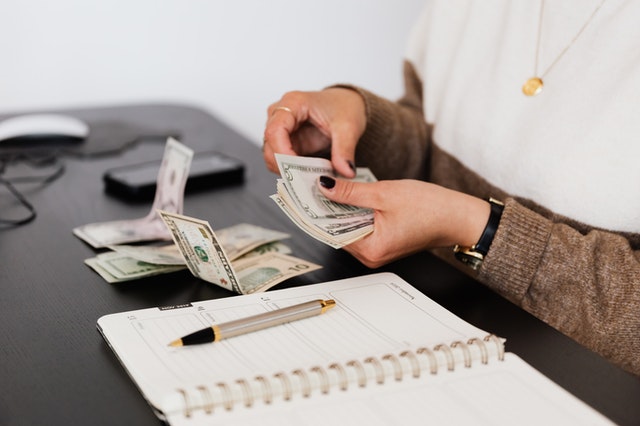 A Property Manager Counting Out Cash from a Rent Payment