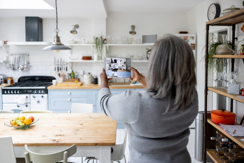 Woman taking pictures and video of rental house using a tablet computer.