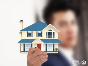 Man holding up an image of a house