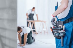 Close-up of handyman with glove on hand and tool belt.