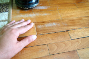 Scratched old parquet flooring needing maintenance. 