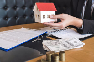 Estate agent holding house model after signing agreement contract. 