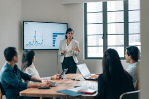 team meeting with screen showing graph