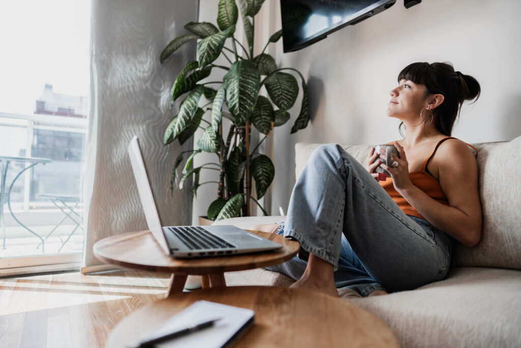 Rental property resident using her laptop while sitting on a cozy couch. 