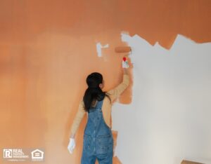 Woman painting the walls of her living room.