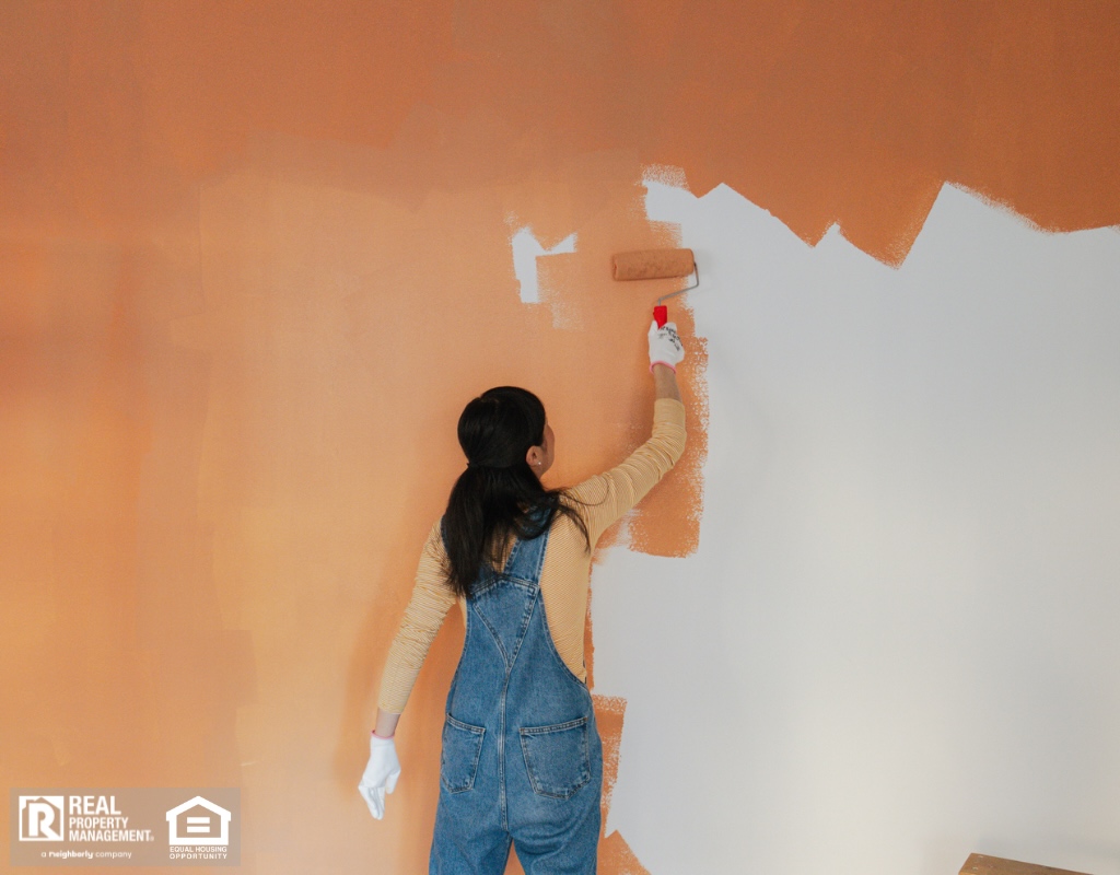 Woman painting the walls of her living room.