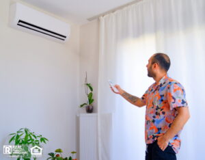Man adjusts air conditioner for fresher indoor air.