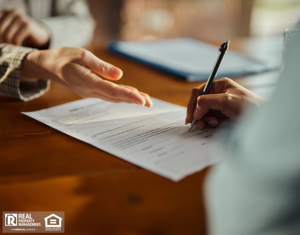 Close up of woman’s hand signing a contract during a meeting with a property manager.