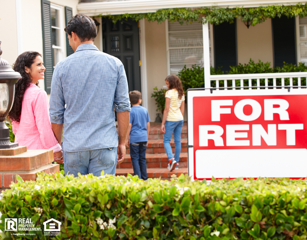 family outside home for rent holding hands looking at each other happy