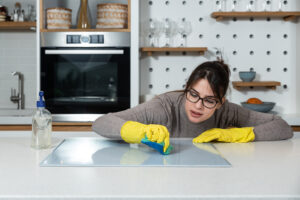 Female cleaning Menlo Park rental home with yellow rubber protective gloves