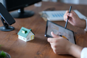 A property manager reviewing rental property reports and investment data on a tablet.
