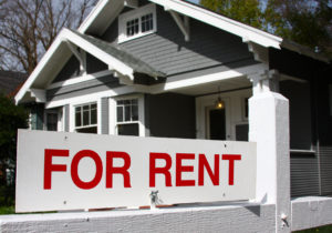 For rent sign in front of gray and white home