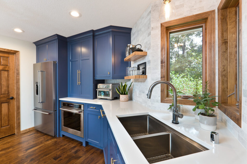 Contemporary blue kitchen with renovated windows, cabinets, and countertops. 