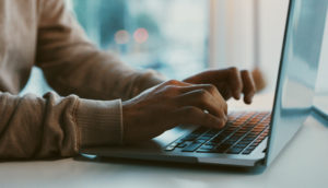 Shot of an unrecognizable businessperson working on their laptop in the office