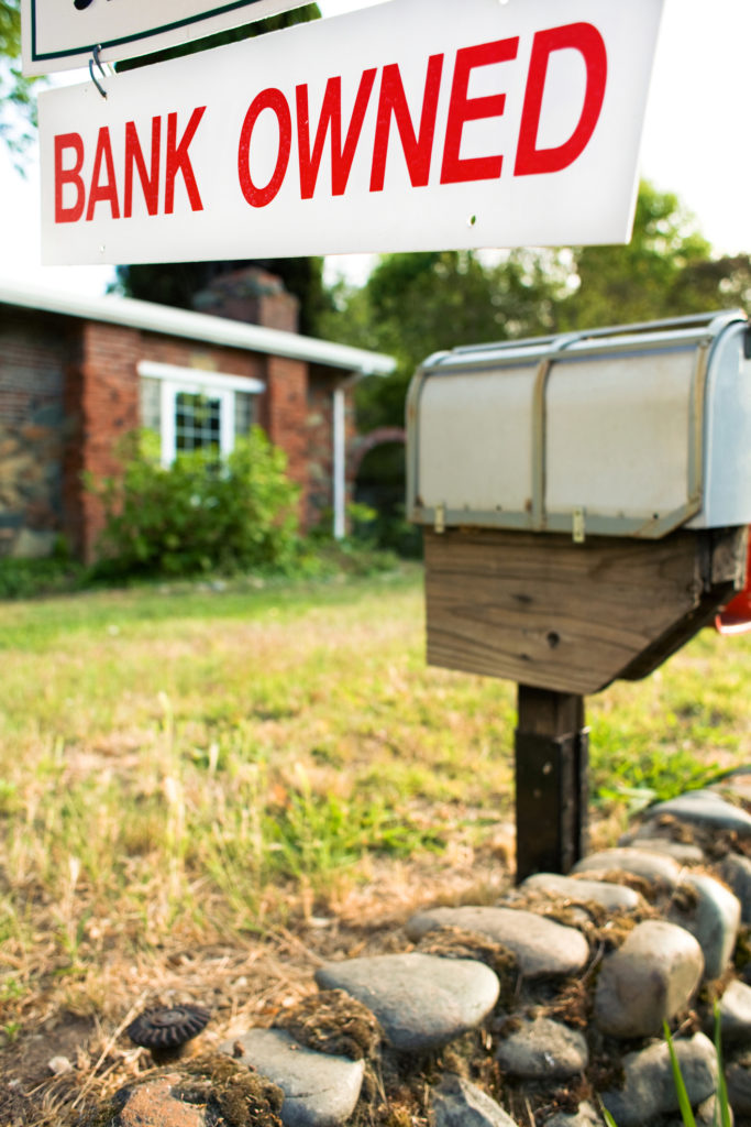 Bank owned sign in front of a home for sale