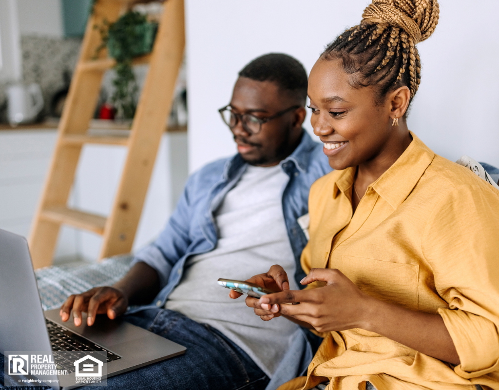Couple engaged in a rental search on their laptop and mobile device.
