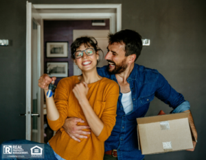 Excited renters holding their house keys and moving boxes.