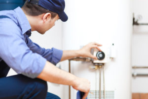 Man Fixing a Water Heater in Elk Ridge Rental Property