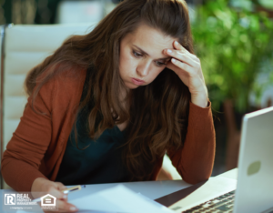 A frustrated property owner works on her laptop.