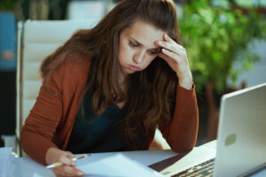 A frustrated property owner works on her laptop. 