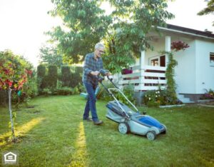 A resident mowing their lawn on a sunny day.