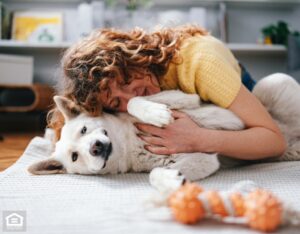 A woman enjoying quality time with her dog, showing affection while lying in a comfortable rental home.