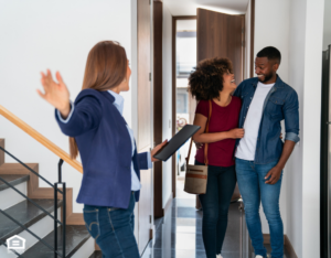 A property manager shows a happy couple their home.