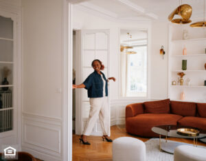 A happy tenant walks into her apartment living room.
