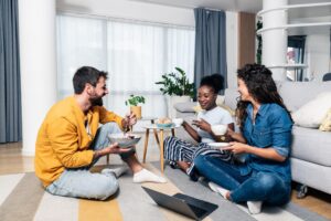 Three roommates gathered at a table in their cozy co-living space.