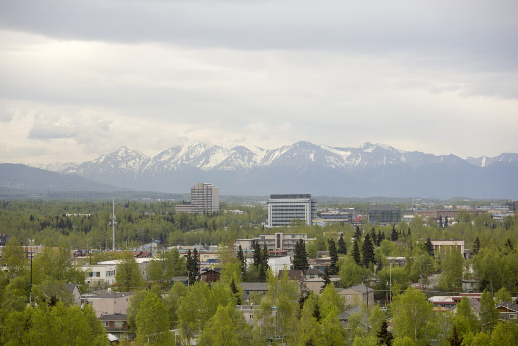 The Alaska Range serves as a dramatic backdrop to the cityscape of downtown Anchorage.