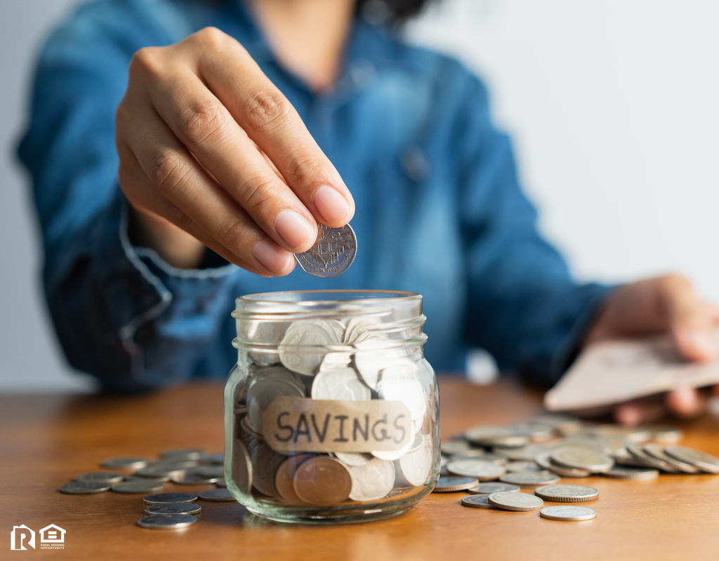 Woman Dropping Change into a Jar Labeled Savings