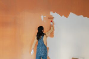 Woman painting the walls of her living room.