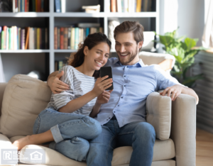 Couple in Weymouth Apartment Smiling at a Smartphone