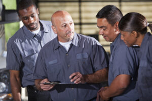 maintenance staff paying attention to man holding clipboard