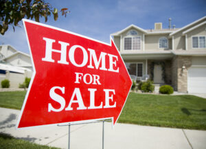 arrow sign with home for sale pointing to a house