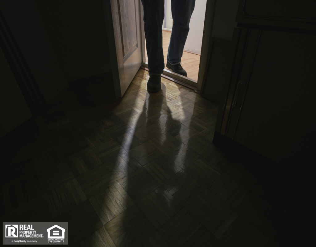 Suspicious person entering room with lights turned off.