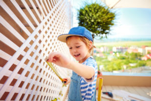 Young Conroe Resident Measuring the Trellis on an Outdoor Patio