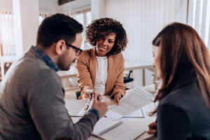 Three people gathered around a table to discuss and finalize a lease agreement.