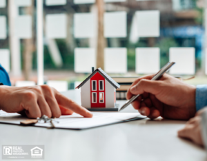 Two people sign a contract while holding a model house, symbolizing landlord insurance and property management.